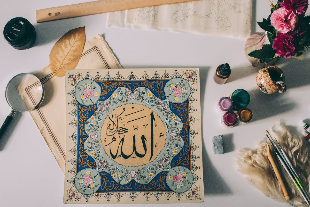 services-img A beautiful flat lay of Islamic calligraphy artwork with paint supplies and decorative elements.