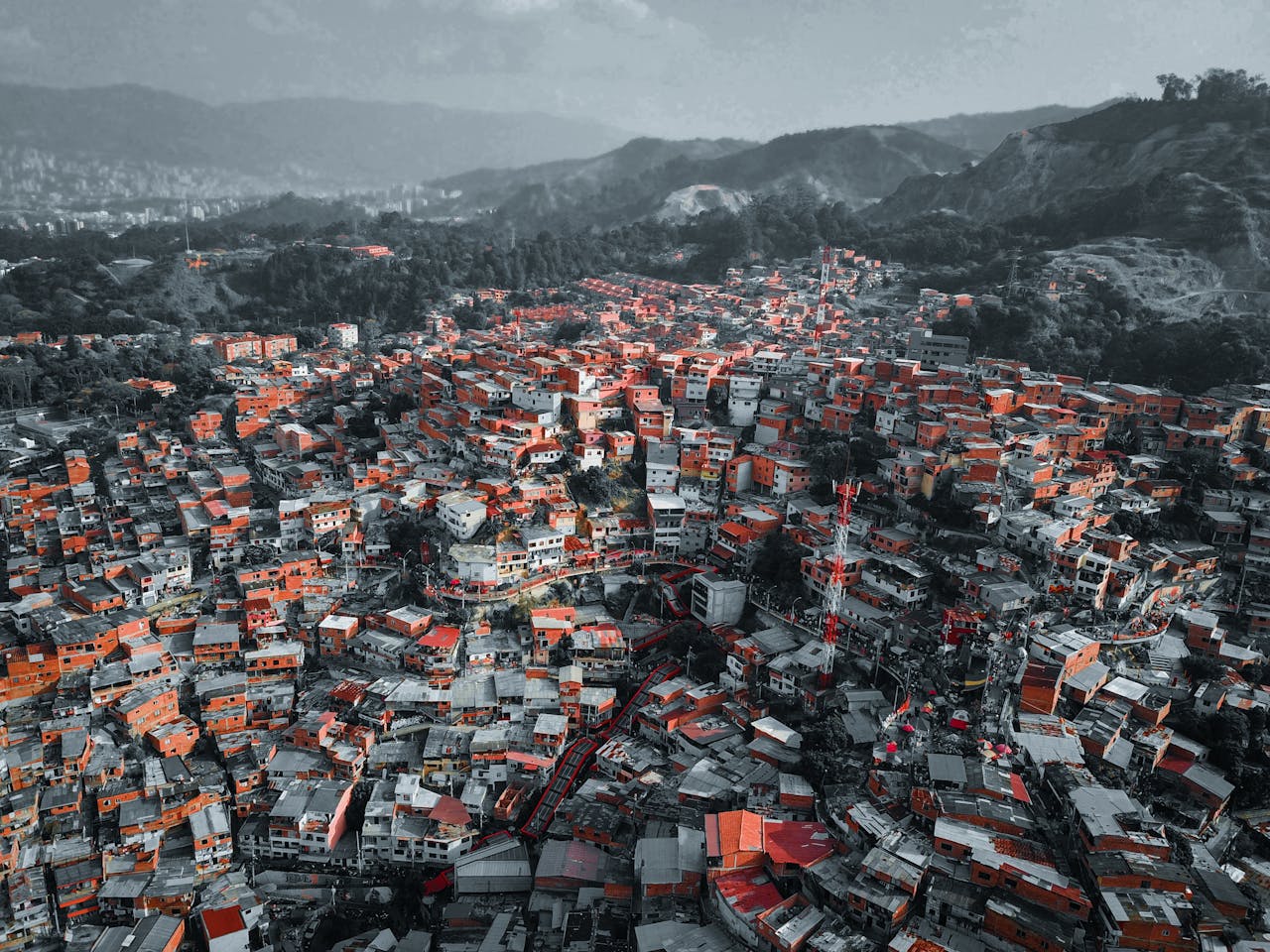 about-02 Colorful urban landscape of Medellín viewed from above, showcasing dense housing and surrounding hills.